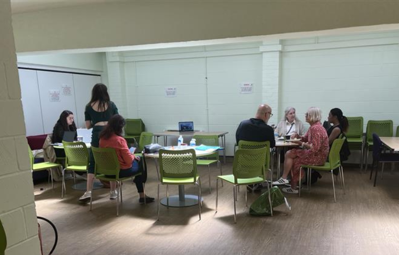 Healthwatch staff members and volunteers seated at tables