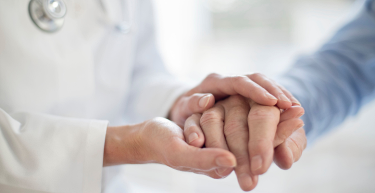 Patient and doctor holding hands