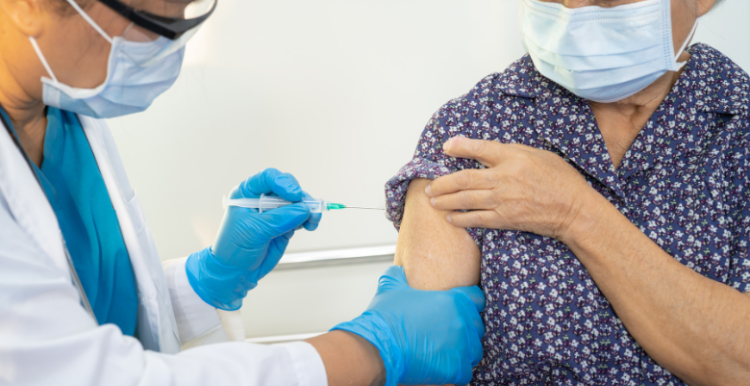 Doctor vaccinating an elderly patient