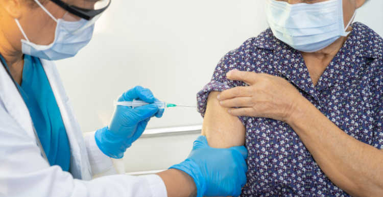 Doctor vaccinating an elderly patient 