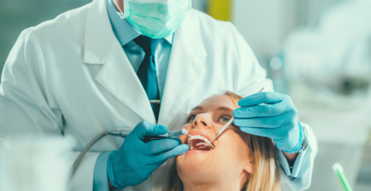 A male dentist doing a checkup on a female patient.