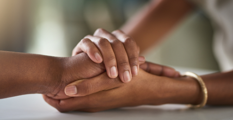 A picture of two hands embraced in a loving way.