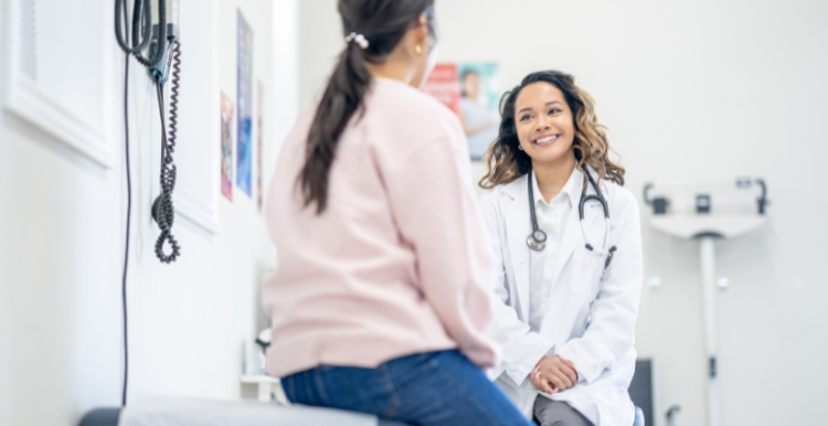 A female patient sitting down and talking to a female doctor.