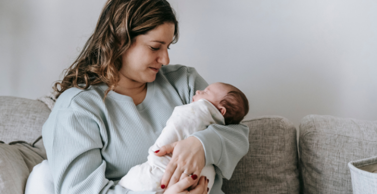 A woman looking at her newborn baby.