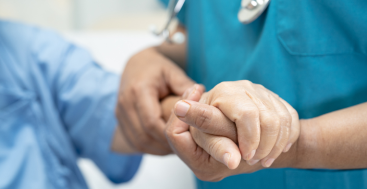 Doctor holding hands of elderly patient