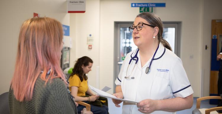 A female doctor talking to a patient in the corridor of the hospital