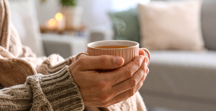 Hands holding a cup of hot drink