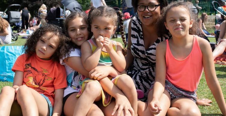 Family sitting in a park together at a Healthwatch event