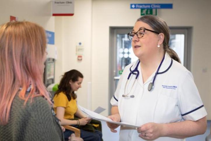A female doctor talking to a patient in the corridor of the hospital