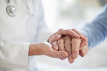 Patient and doctor holding hands