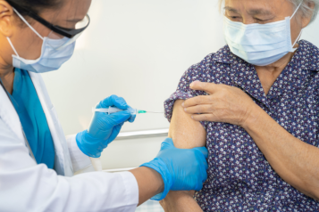 Doctor vaccinating an elderly patient 