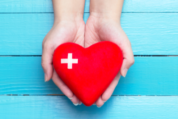 One pair of hands holding a 3D heart shape.