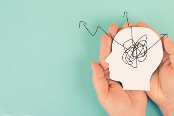 Picture of two hands holding an image of the mind with thoughts in it to represent mental health.