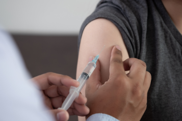 Picture of a doctor administering a vaccine to a patient.