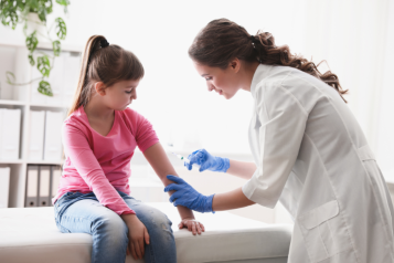 A nurse vaccinating a young girl.