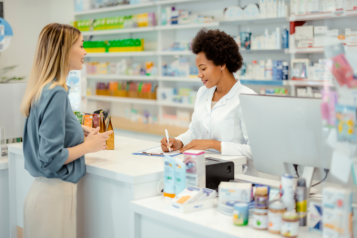 A pharmacist offering advice to a patient about their medication.