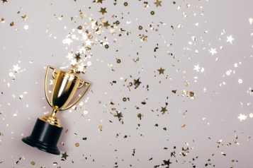A trophy with a background of confetti.