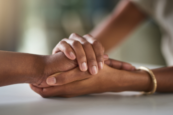 A picture of two hands embraced in a loving way.