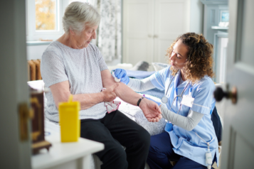 Female nurse taking a blood test from a female older patient.
