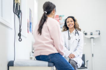 A female patient sitting down and talking to a female doctor.