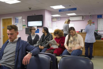 A group of patients sitting in the waiting area in a hospital or GP.