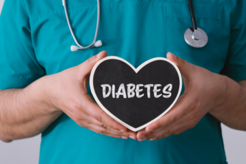 A healthcare professional holding a black, heart shaped object which says Diabetes.