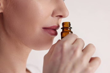 A woman smelling a bottle of perfume