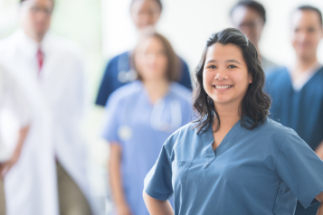 A group of doctors and nurses standing together and smiling.