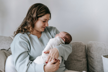 A woman looking at her newborn baby.