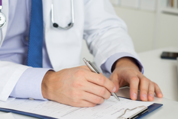 A doctor signing a document