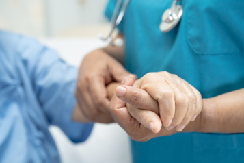 Doctor holding hands of elderly patient