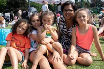 Family sitting in a park together at a Healthwatch event