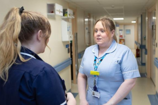 Two medical professionals talking to eachother.