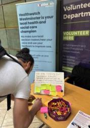 A man writing on a post it note at a hospital table